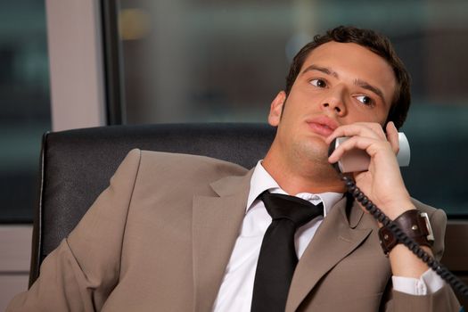 Businessman using telephone in an office
