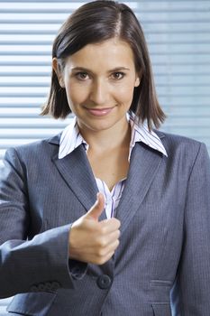 Portrait of smiling businesswoman showing thumbs up
