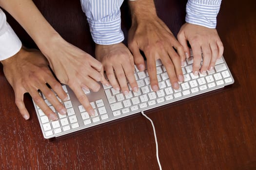 Human hands on computer keyboard, elevated view