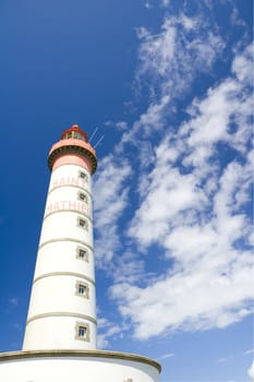 shot of lighthouse in brittany, france beyond blue, cloudy sky