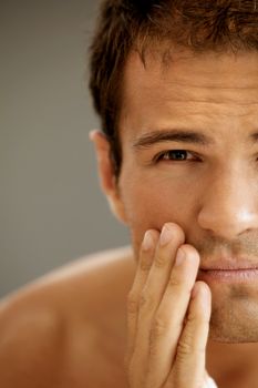 Close-up of young man applying shaving cream
