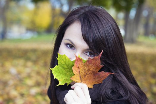 Girl with colorful leaves in the park.