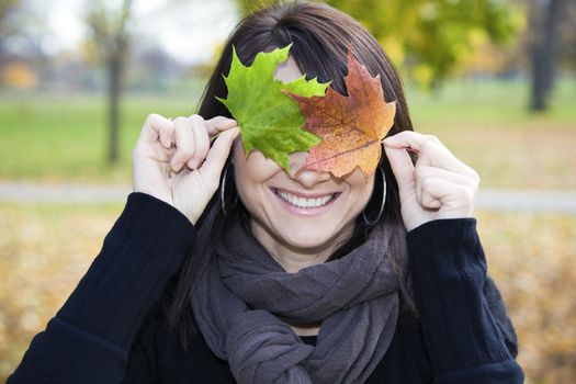 Smiling Girl with two colorful leaves