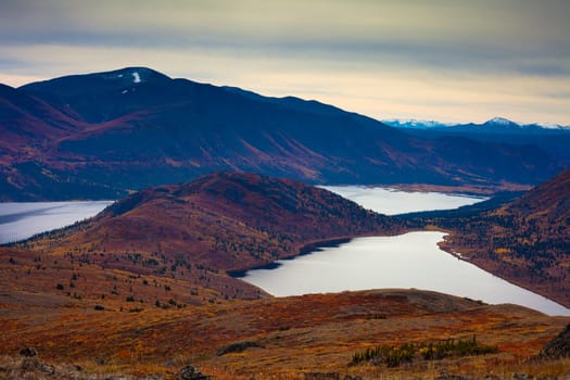 Fall-colored alpine tundra surrounding mountain lakes in Yukon Territory, Canada.
