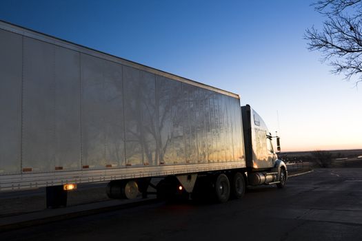 White Semi Truck seen at sunrise