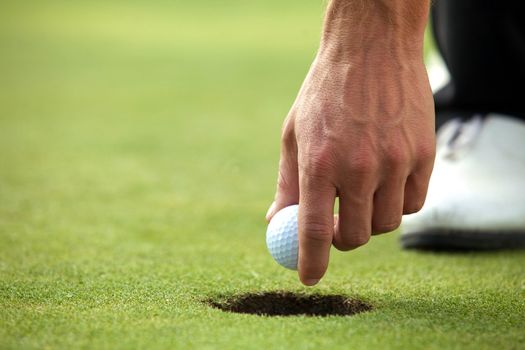 Person holding golf ball, close-up
