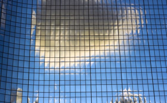 Clouds reflected in the windows of office building.