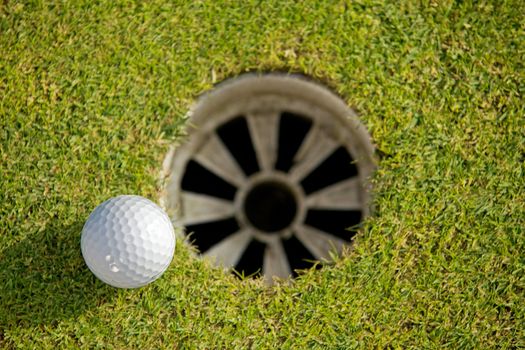 Close-up of golf ball near hole
