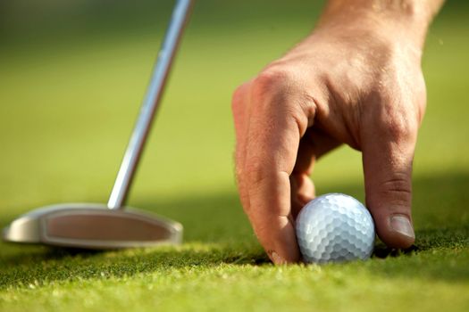 Person holding golf ball, close-up
