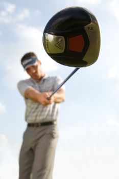 Young man playing golf, low angle view