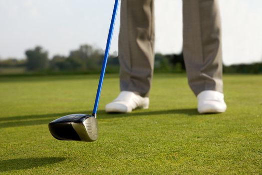 Person holding golf stick, low section