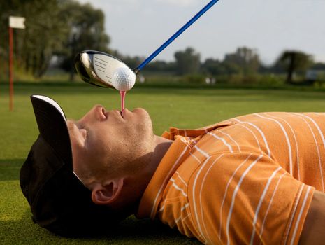 Man balancing golf ball on tee in his mouth