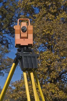 Theodolite against a tree - fall land surveying.