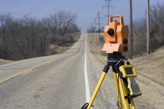 Theodolite set on the edge of road - spring land surveying.