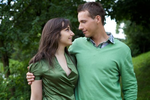 Young couple with arm around and looking at each other