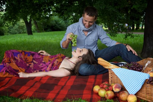 Young man feeding girlfriend at park