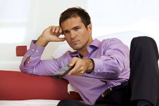 Young man on bed using remote control
