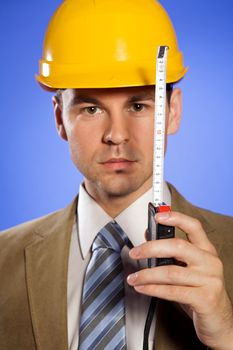 Portrait of businessman in hardhat holding tape measure