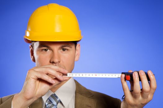 Portrait of businessman in hardhat holding tape measure