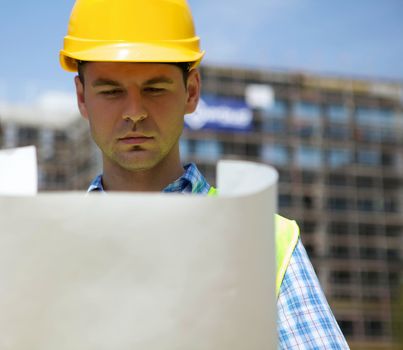 Engineer looking at blueprint on construction site