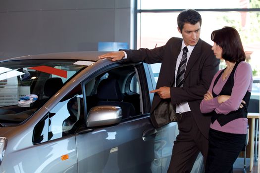 Car salesman explaining car features to customer