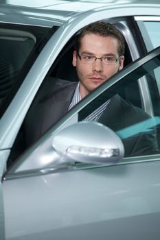 Car salesperson getting in car at showroom