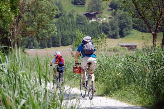 Father and son cycling through austrian Landscape.