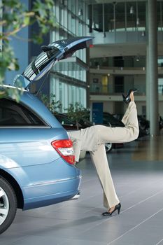 Low section of female customer examining car interior
