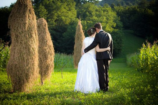 Young married couple walking on a countryside field