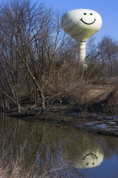 Smiling Water Tower reflected in river.