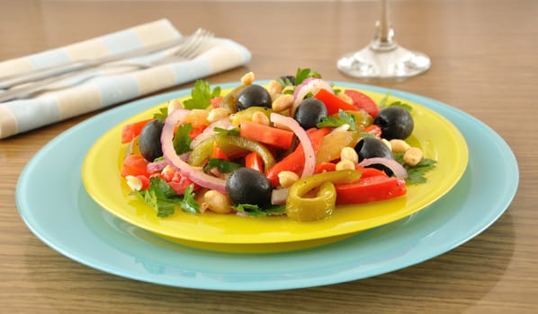 Salad of roasted peppers with tomato, peanuts and olives, onions and greens 