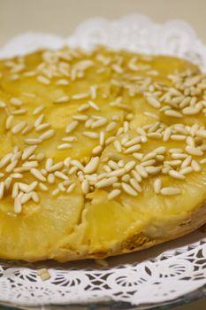 Close view of a homemade pineapple cake decorated with pine nuts.