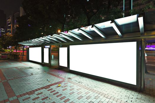 Blank billboard on bus stop at night