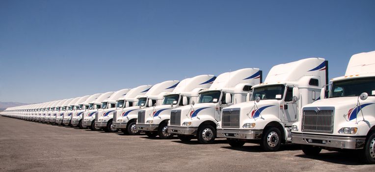 Semi truck fleet lined up in a row with copy space
