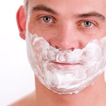 Young man with shaving foam on his face