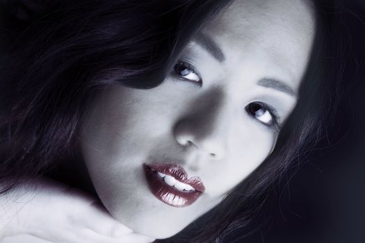 Young chinese girl on a dark background