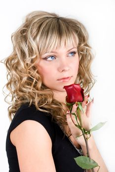 Close-up of the young blond girl face with a rose