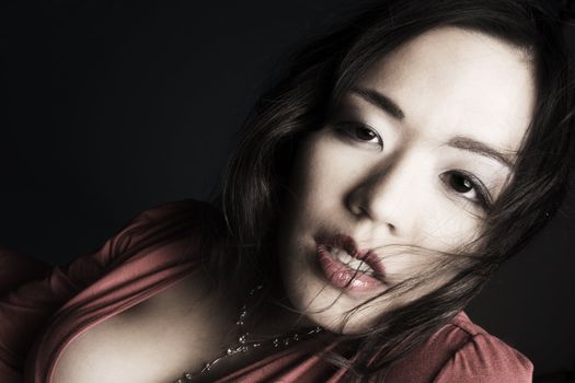 Young chinese girl on a dark background