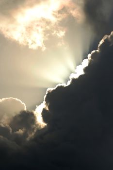 Suns rays streaming out from behind a large cloud