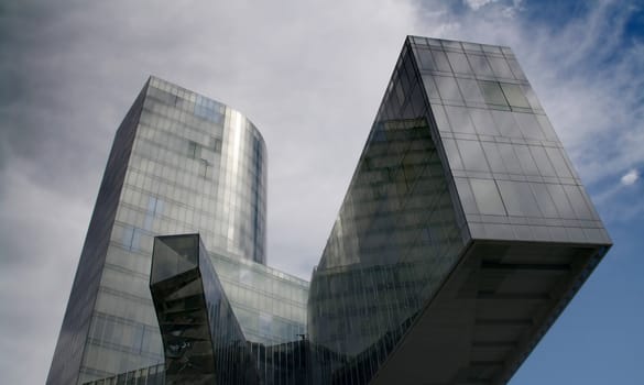 Business building, blue glass, clouded sky background