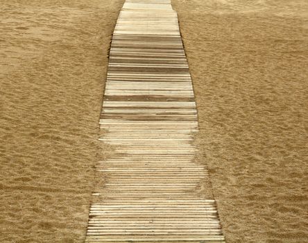 wooden boards path on the sand on a beach