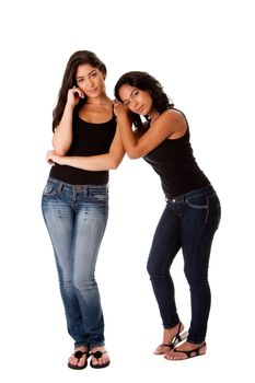 Beautiful happy young woman couple together standing, resting on shoulder, both dressed in black tank top and blue denim jeans, isolated.