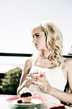 beautiful woman sits at restaurant table with wine by herself