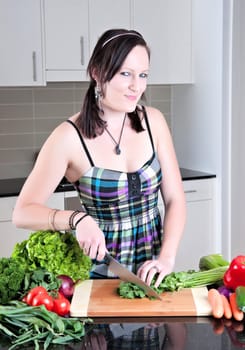 pretty young woman chopping and preparing vegetables