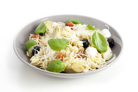 Bowl of pasta salad on white background.