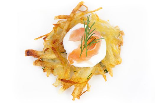 Bite sized potato rosti appetizer topped with fresh sour cream, smoked salmon and dill viewed from directly above