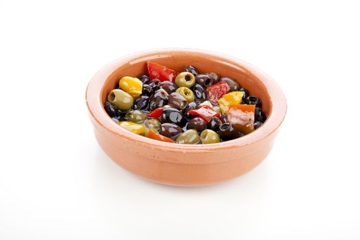 Earthenware bowl of Spanish tapas olives isolated on white background.