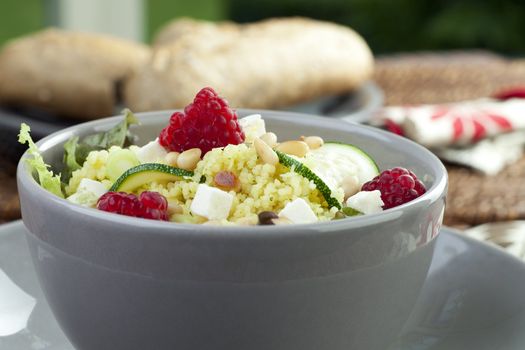 Delicious bowl of couscous salad with raspberries