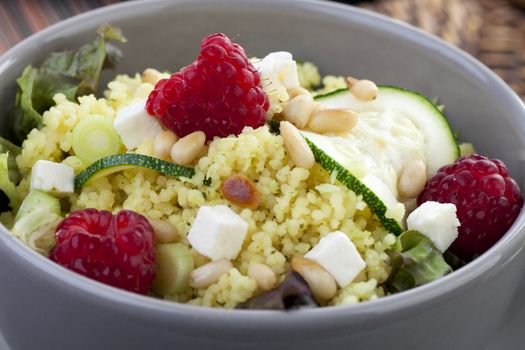 Couscous salad with zucchini and raspberries and pine nuts.