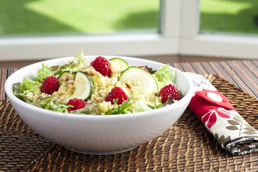 Couscous salad with zucchini and raspberries and pine nuts.